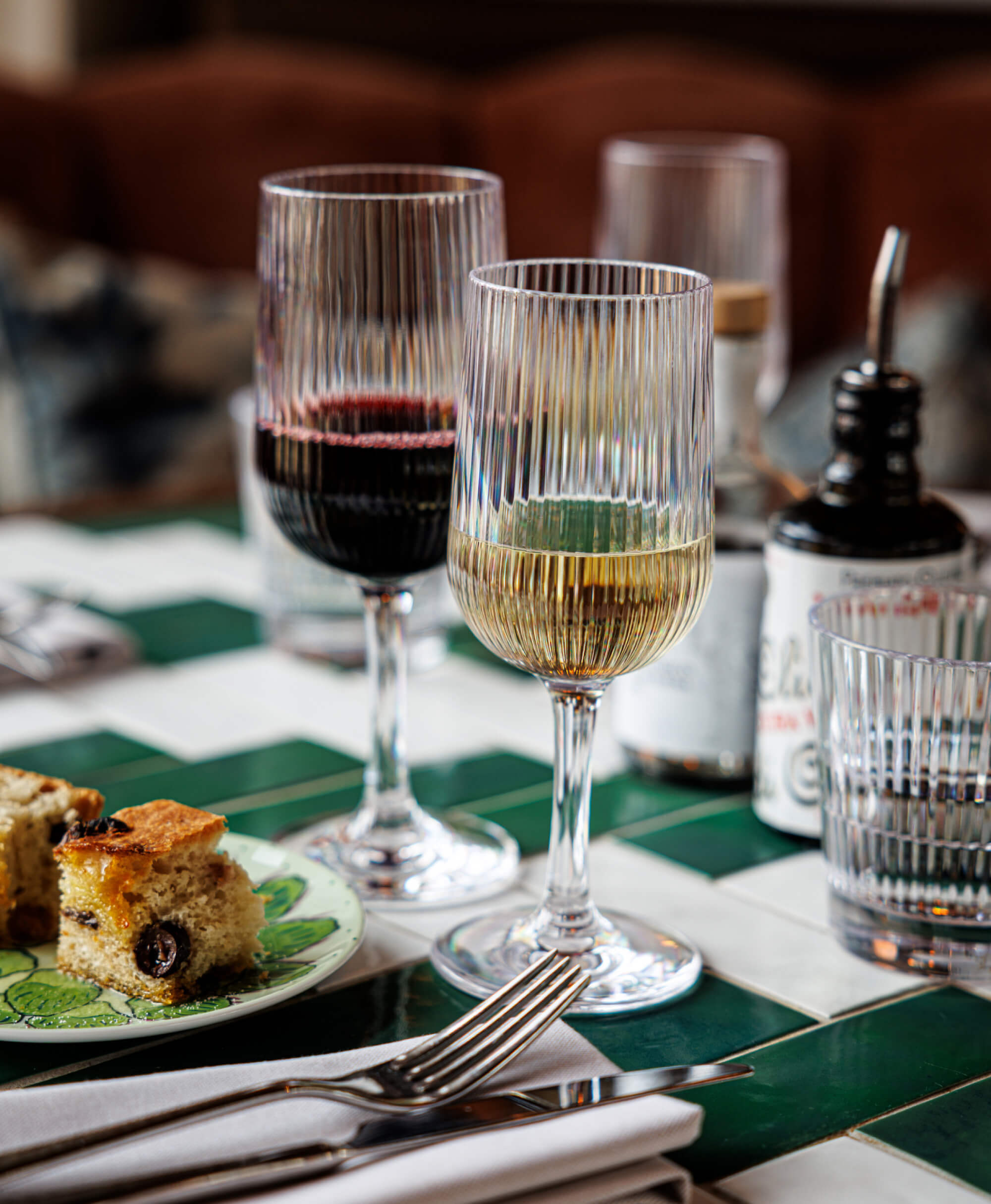 Okrossbara plastvinsglas med randig design - elegant dukning med rött och vitt vin, gourmet-kaka och stilfull bordsdekoration<br />
